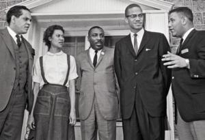 Réunion à Chester, Pennsylvanie, organisée par le Comité Freedom Now, le 14 mars 1964, pour fonder le groupe de défense des droits des Noirs ACT. De gauche à droite, Lawrence Landry, leader du boycott des écoles de Chicago ; Gloria Richardson ; le comédien Dick Gregory ; Malcolm X ; et Stanley Branche, président du comité.